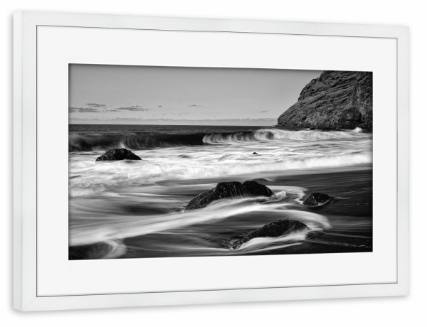 Poster mit Rahmen weiß "Schwarzer Vulkanstrand mit Steinen" artboxONE - Natur,Reise,Schwarzweiß,Reise / Strand und Meer