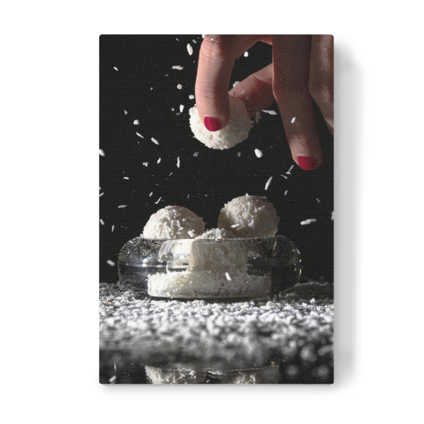 Leinwandbild "Schwer zu widerstehen" artboxONE - Essen & Trinken - Kokos,Pralinen,Raffaelo,Schokolade,Schwarz,Weiß,Essen,Finger,Hände